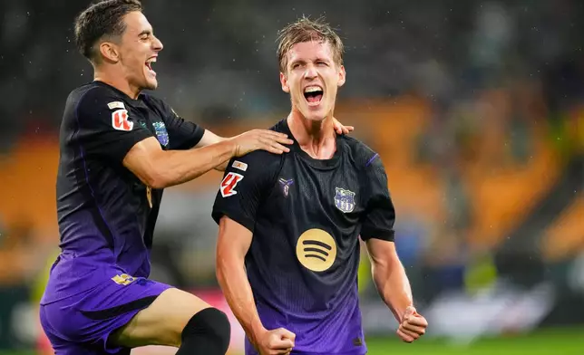 Barcelona's Dani Olmo, right, celebrates after scoring during the Spanish La Liga soccer match between Real Betis and Barcelona in Seville, Spain, Saturday, Oct. 17, 2026. (AP Photo/Jose Breton)