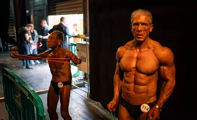 Japanese bodybuilder Toshisuke Kanazawa, 90, left, prepares to compete in the 2026 IFBB World Fitness and Bodybuilding Championships in Santa Susanna, Spain, Friday, Oct. 30, 2026. (AP Photo/Pau Venteo)
