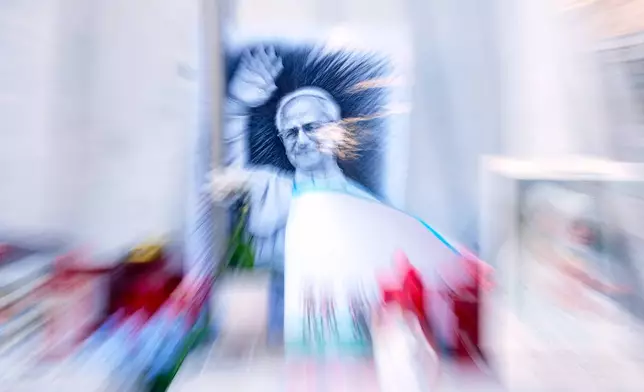 An image of Pope Leo XIV is seen under the statue of late Pope St. John Paul II at the Agostino Gemelli Polyclinic where the pontiff is hospitalised, in Rome, Friday, Oct. 16, 2026. (AP Photo/Gregorio Borgia)