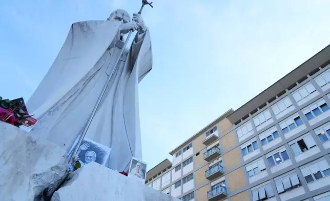 An image of Pope Leo XIV is seen under the statue of late Pope St. John Paul II at the Agostino Gemelli Polyclinic where the pontiff is hospitalised, in Rome, Friday, Oct. 16, 2026. (AP Photo/Gregorio Borgia)