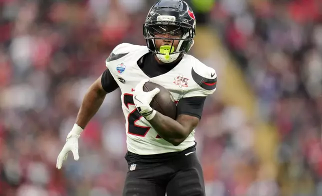 Houston Texans running back Jawhar Jordan (25) runs in to score a touchdown during an NFL football game against Jacksonville Jaguars in London, Sunday, Oct. 18, 2026. (AP Photo/Kin Cheung)