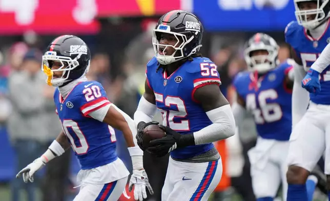 New York Giants linebacker Arvell Reese (52) celebrates his interception against the Arizona Cardinals with Giants cornerback Greg Newsome II (20) during an NFL football game, in East Rutherford, N.J., Sunday, Oct. 4, 2026. (AP Photo/Seth Wenig)