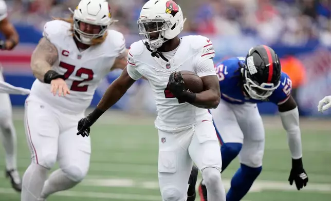 Arizona Cardinals running back Jeremiyah Love, center, runs with the ball as Cardinals center Hjalte Froholdt (72) blocks New York Giants linebacker Arvell Reese (52) during an NFL football game, in East Rutherford, N.J., Sunday, Oct. 4, 2026. (AP Photo/Seth Wenig)