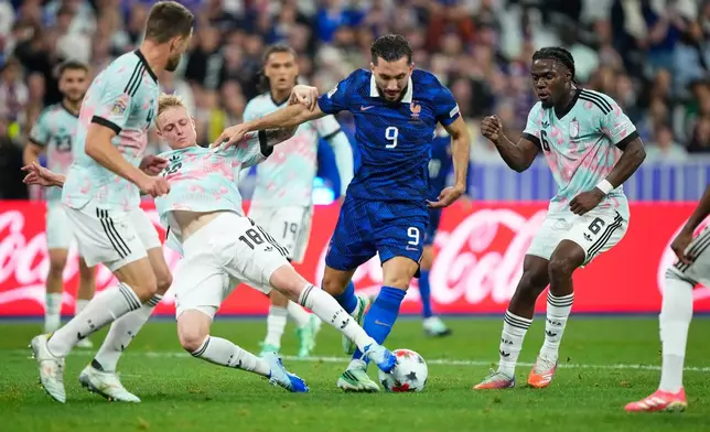 France's Rayan Cherki, centre, challenges for the ball with Belgium's Joaquin Seys, centre left, during the Nations League soccer match between France and Belgium in Saint-Denis near Paris, Monday, Oct. 5, 2026. (AP Photo/Teresa Suarez)