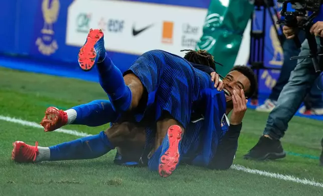 France's Desire Doue and France's Michael Olise celebrate after scoring during the Nations League soccer match between France and Belgium in Saint-Denis near Paris, Monday, Oct. 5, 2026. (AP Photo/Teresa Suarez)