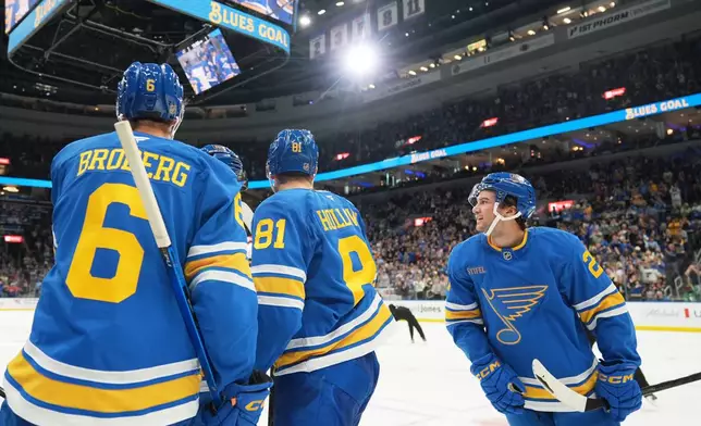 St. Louis Blues' Jimmy Snuggerud, right, celebrates with teammates after scoring his first goal of the second period of an NHL hockey against the Columbus Blue Jackets game Saturday, Oct. 10, 2026, in St. Louis. (AP Photo/Jeff Roberson)