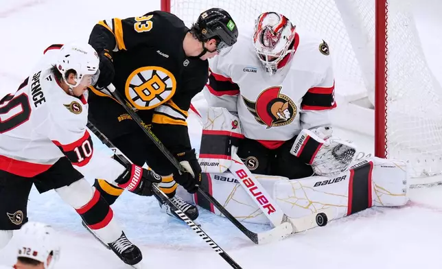 Ottawa Senators' Linus Ullmark, right, makes a save on a shot by Boston Bruins' Fraser Minten (93) during the first period of an NHL hockey game, Monday, Oct. 5, 2026, in Boston. (AP Photo/Charles Krupa)