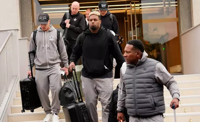 New Orleans Saints' Cameron Jordan, center, arrives at the reception pavilion of Charles de Gaulle airport in Roissy north of Paris, Monday, Oct. 19, 2026. (AP Photo/Teresa Suarez)