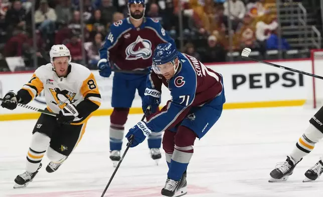 Colorado Avalanche left wing Jaden Schwartz (71) collects the puck as Pittsburgh Penguins center Ben Kindel, left, pursues in the first period of an NHL hockey game, Friday, Oct. 16, 2026, in Denver. (AP Photo/David Zalubowski)