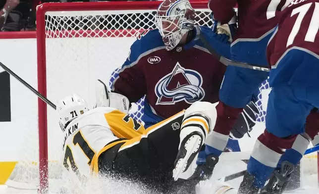 Pittsburgh Penguins center Evgeni Malkin, left, scores past Colorado Avalanche goaltender Mackenzie Blackwood, second from left, in the first period of an NHL hockey game, Friday, Oct. 16, 2026, in Denver. (AP Photo/David Zalubowski)