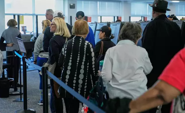 Voters wait in line to receive their ballots at early in-person voting in Cleveland, Wednesday, Oct. 7, 2026. (AP Photo/Sue Ogrocki)