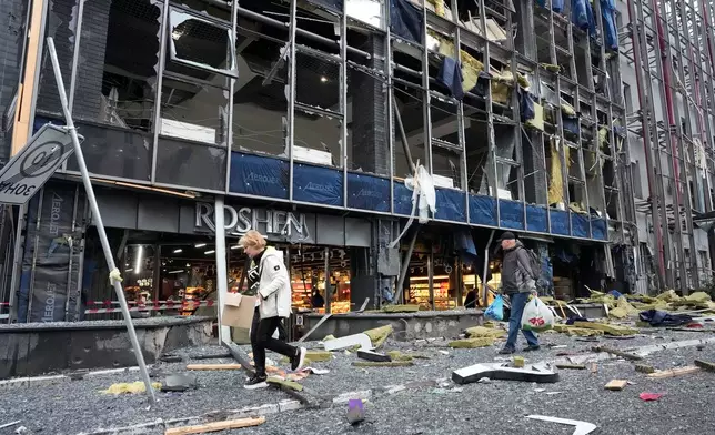 People carry their belongings as they leave their office following Russian air attack in Kyiv, Ukraine, Monday, Oct. 19, 2026. (AP Photo/Efrem Lukatsky)