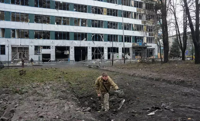 A Ukrainian serviceman inspects a missile crater after a Russian air attack in central Kyiv, Ukraine, Monday, Oct. 19, 2026. (AP Photo/Efrem Lukatsky)