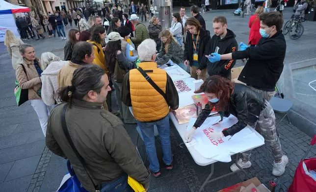 University students talk with citizens on the main pedestrian street in downtown Belgrade, Serbia, on Oct. 14, 2026. (AP Photo/Darko Vojinovic)