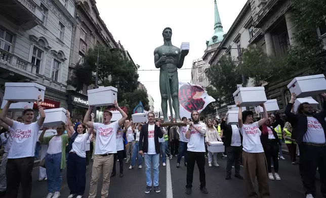 Students, political candidates and citizens hold a replica of the "Victor" monument, a symbol of Belgrade, and carry signatures for the "Student list - Students win" to the Republic Election Commission towards participation in the upcoming parliamentary elections, in Belgrade, Serbia, on Sept. 14, 2026. (AP Photo/Darko Vojinovic)