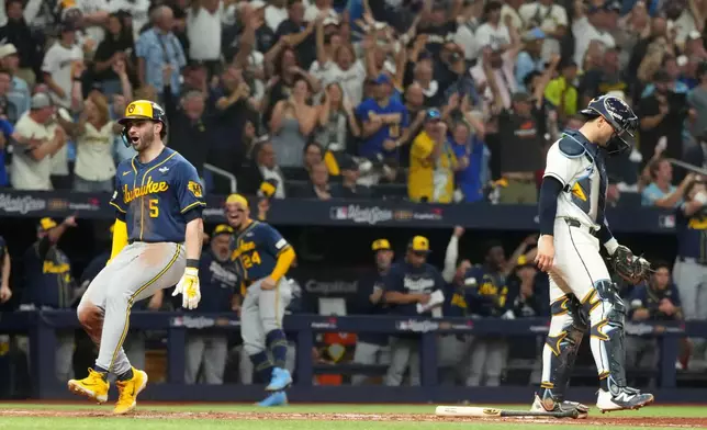 Milwaukee Brewers' Garrett Mitchell, left, celebrates past Tampa Bay Rays catcher Nick Fortes after scoring during the fifth inning of Game 3 of baseball's World Series, Monday, Oct. 26, 2026, in St. Petersburg, Fla., between the Milwaukee Brewers and the Tampa Bay Rays. (AP Photo/Ashley Landis)