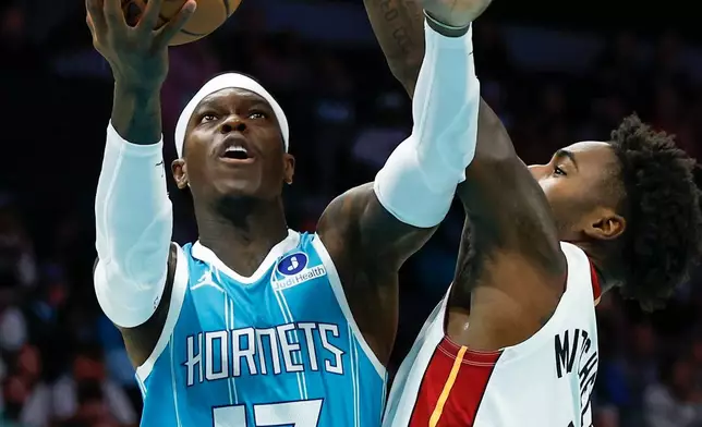 Charlotte Hornets guard Dennis Schroder (17) looks to shoot against Miami Heat guard Davion Mitchell, right, during the first half of an NBA basketball game in Charlotte, N.C., Saturday, Oct. 24, 2026. (AP Photo/Nell Redmond)