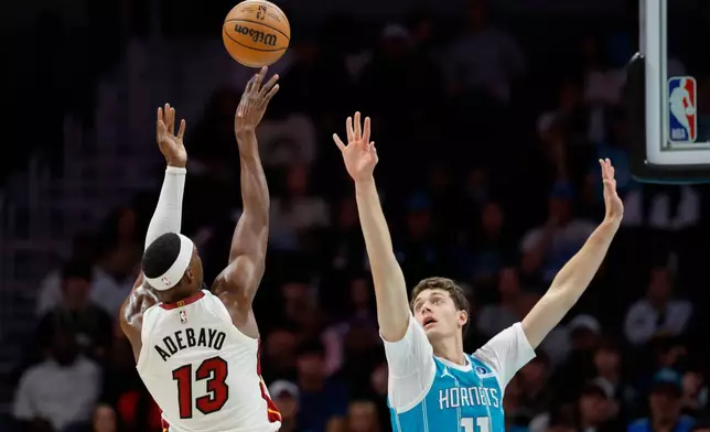 Miami Heat center Bam Adebayo (13) shoots over Charlotte Hornets center Ryan Kalkbrenner (11) during the first half of an NBA basketball game in Charlotte, N.C., Saturday, Oct. 24, 2026. (AP Photo/Nell Redmond)