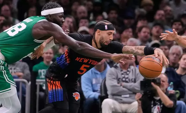 New York Knicks' Jose Alvarado (5) reaches for the ball against Boston Celtics' Neemias Queta, left, during the first half of an NBA basketball game, Friday, Oct. 23, 2026, in Boston. (AP Photo/Charles Krupa)