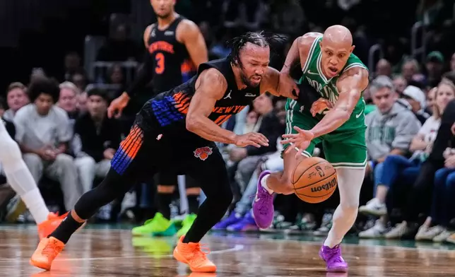 New York Knicks' Jalen Brunson, left, and Boston Celtics' Jordan Walsh, right, battle for the ball during the first half of an NBA basketball game, Friday, Oct. 23, 2026, in Boston. (AP Photo/Charles Krupa)