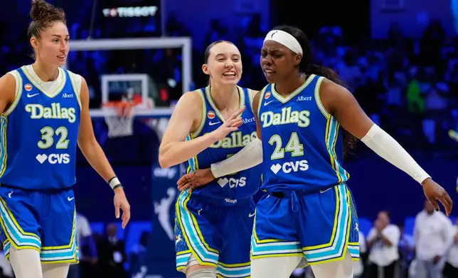 Dallas Wings' Jessica Shepard (32), Paige Bueckers (5) and Arike Ogunbowale (24) celebrate after Ogunbowale sunk a three-pointer in overtime of a WNBA basketball first-round playoff game against the Golden State Valkyries Wednesday Sept. 30, 2026, in Arlington, Texas. (AP Photo/Tony Gutierrez)