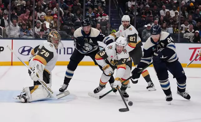 Vegas Golden Knights defenseman Brayden McNabb (3) clears the puck away from Columbus Blue Jackets right wing Mathieu Olivier (24) during the second period of an NHL hockey game Saturday, Oct. 24, 2026, in Columbus, Ohio. (AP Photo/Joshua A. Bickel)