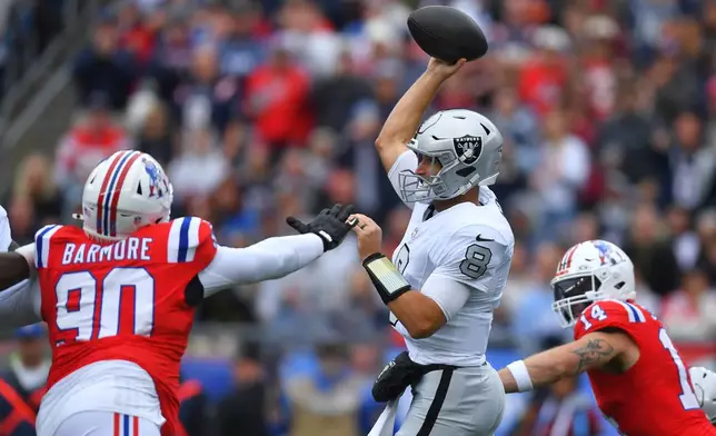 Las Vegas Raiders quarterback Kirk Cousins (8) throws a pass under pressure from New England Patriots defensive tackle Christian Barmore (90) during an NFL football game in Foxborough, Mass., Sunday, Oct. 11, 2026. (AP Photo/Steven Senne)