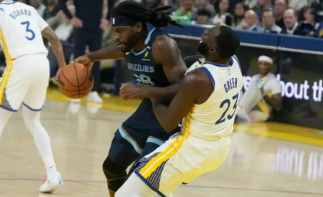 Memphis Grizzlies forward/center Isaiah Stewart, left, is called for a foul while driving to the basket against Golden State Warriors forward/center Draymond Green during the first half of an NBA basketball game, Friday, Oct. 23, 2026, in San Francisco. (AP Photo/Jeff Chiu)