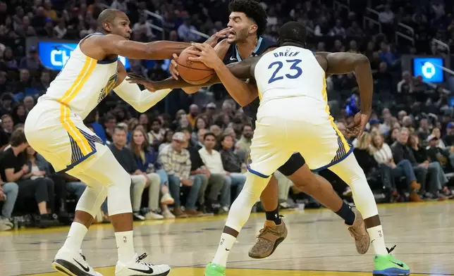 Memphis Grizzlies forward Cameron Boozer, middle, drives to the basket against Golden State Warriors center Al Horford, left, and forward/center Draymond Green during the first half of an NBA basketball game, Friday, Oct. 23, 2026, in San Francisco. (AP Photo/Jeff Chiu)