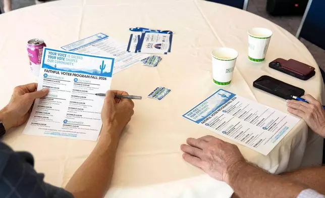 Rev. Dan Hoeger and Brad Weintraub review a list of upcoming events during a training from Arizona Faith Network for poll chaplains and peacekeepers, Tuesday, Oct. 6, 2026, ahead of the upcoming general midterm election, at Temple Chai in Scottsdale, Ariz. (AP Photo/Rebecca Noble)