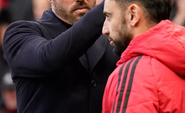 Manchester United's head coach Michael Carrick applauds to supporters as Manchester United's Bruno Fernandes passes ahead of the start of the English Premier League soccer match between Manchester United and Bournemouth in Manchester, England, Sunday, Oct. 25, 2026. (AP Photo/Dave Thompson)