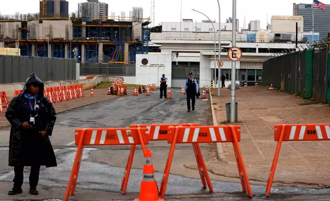 Security personnel stand behind barricades outside the U.S. Embassy after consular services were suspended due to security concerns in Brasilia, Brazil, Friday, Oct. 2, 2026. (AP Photo/Eraldo Peres)