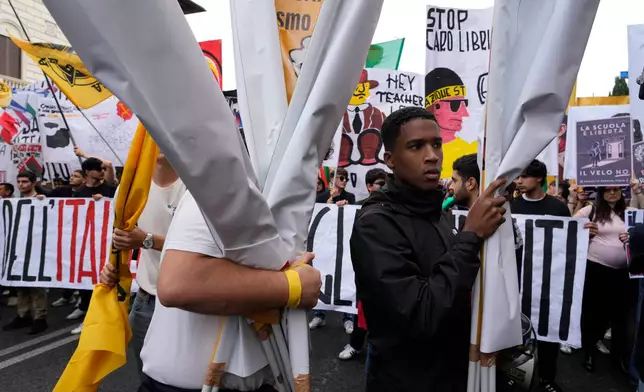 Members of right-wing student groups march through the streets of Rome, Saturday, Oct. 24, 2026, during a demonstration called "Unlock Everything," organized in opposition to recent left-wing student protests and one of several demonstrations held by groups across the political spectrum. (AP Photo/Gregorio Borgia)
