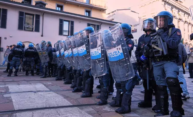 Anti-riot police watch as demonstrators march through the streets of Milan, Italy, Saturday, Oct. 24, 2026, to protest against the rising cost of living and deteriorating public services, during one of several demonstrations organized across Italy by groups spanning the political spectrum. (AP Photo/Antonio Calanni)