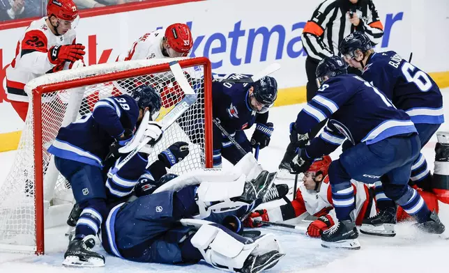 Winnipeg Jets goaltender Clay Stevenson (33) saves the loose puck against Carolina Hurricanes during the second period of an NHL hockey game in Winnipeg, Manitoba, Saturday, Oct. 17, 2026. (John Woods/The Canadian Press via AP)