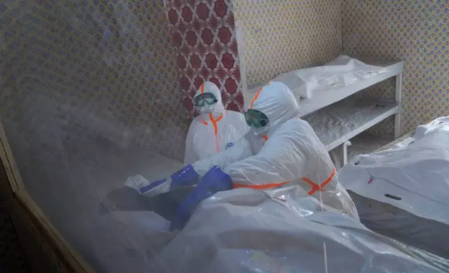 Health workers prepare to transfer the body of Abineno Justine, a 38-year-old woman who died of the Ebola virus, to a coffin ahead of her burial in Bunia, Congo, Friday, Sept. 4, 2026. (AP Photo/Dieudonne Dirole)