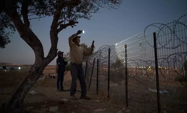 Nayef uses a flashlight after spotting Israeli settlers outside his Palestinian-Bedouin family's house on the outskirts of the West Bank town of Taybeh, Thursday, Sept. 10, 2026. (AP Photo/Leo Correa)