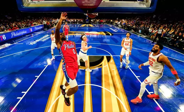 Philadelphia 76ers' Tyrese Maxey, front left, dunks as New York Knicks' Karl-Anthony Towns, right, watches during the first half of an NBA Cup basketball game, Friday, Oct. 30, 2026, in Philadelphia. (AP Photo/Chris Szagola)