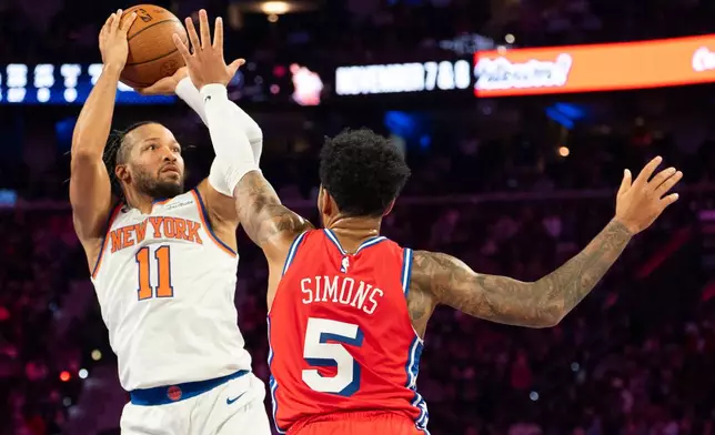 New York Knicks' Jalen Brunson, left, looks to shoot against Philadelphia 76ers' Anfernee Simons, right, during the first half of an NBA Cup basketball game, Friday, Oct. 30, 2026, in Philadelphia. (AP Photo/Chris Szagola)