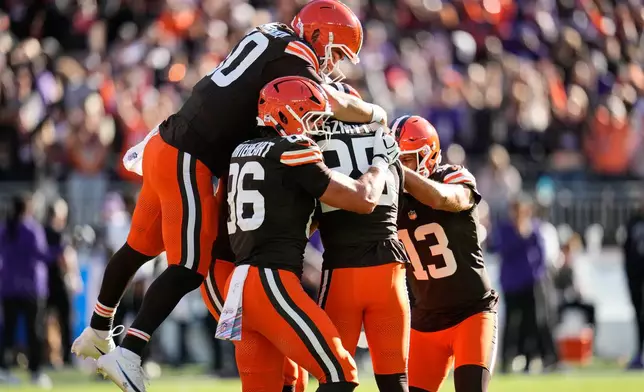 Cleveland Browns long snapper Rex Sunahara, left, and others pile on place kicker Andre Szmyt, second from right, after his game-winning field goal during the second half of an NFL football game against the Baltimore Ravens in Cleveland, Sunday, Oct. 18, 2026. (AP Photo/Sue Ogrocki)
