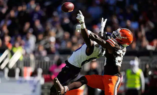 Baltimore Ravens wide receiver Devontez Walker, left, is unable to complete a catch as Cleveland Browns cornerback Myles Harden (26) defends during the first half of an NFL football game in Cleveland, Sunday, Oct. 18, 2026. (AP Photo/Sue Ogrocki)