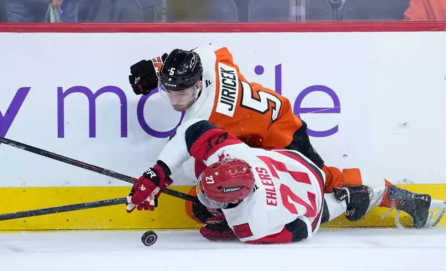 Philadelphia Flyers' David Jiricek (5) collides with Carolina Hurricanes' Nikolaj Ehlers (27) during the third period of an NHL hockey game Sunday, Oct. 11, 2026, in Philadelphia. (AP Photo/Matt Slocum)