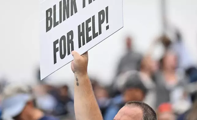 A fan holds up a sign that makes reference to Tennessee Titans quarterback Cam Ward during the second half of an NFL football game against the Houston Texans in Nashville, Tenn., Sunday, Oct. 11, 2026. (AP Photo/John Amis)