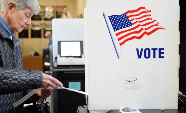 A woman feeds her ballot into a scanning machine at an early voting site in Haverstraw, N.Y., Monday, Oct. 26, 2026. (AP Photo/Seth Wenig)