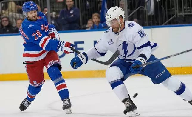 New York Rangers' Oliver Bjorkstrand, left, tries to get the puck past Tampa Bay Lightning's Erik Cernak during the second period of an NHL hockey game in New York, Tuesday, Oct. 13, 2026. (AP Photo/Seth Wenig)