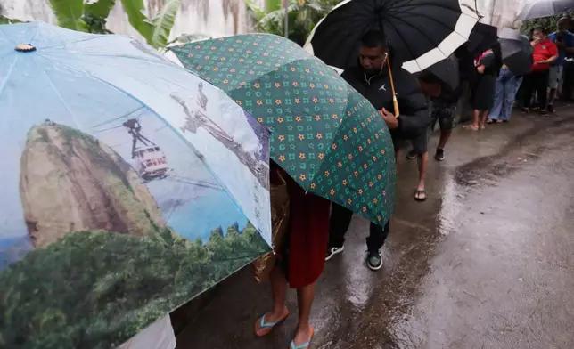 Voters line up to enter a polling station during the presidential runoff in the Rocinha favela in Rio de Janeiro, Brazil, Sunday, Oct. 25, 2026. (AP Photo/Bruna Prado)