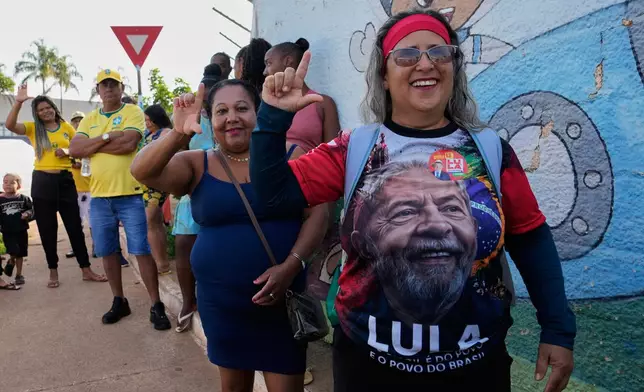 A supporter of President Luiz Inacio Lula da Silva, who is seeking reelection, lines up at a polling station during a presidential runoff in Brasilia, Brazil, Sunday, Oct. 25, 2026. (AP Photo/Eraldo Peres)