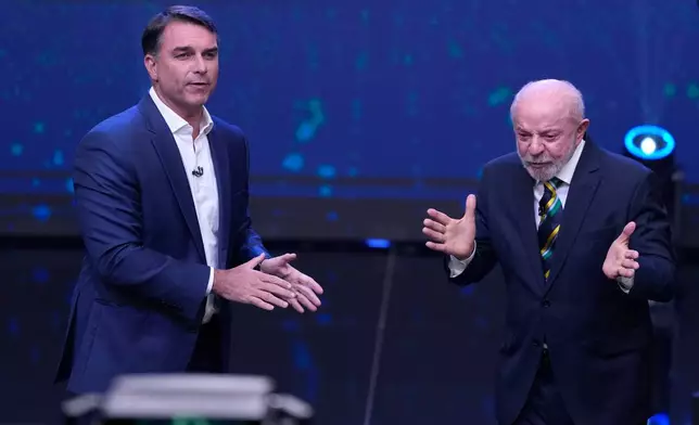 FILE - Brazil President Luiz Inacio Lula da Silva, right, who is running for reelection, gestures as opposition presidential candidate Sen. Flavio Bolsonaro stands beside him during a televised presidential debate one week before the runoff election in Sao Paulo, Brazil, Oct. 18, 2026. (AP Photo/Andre Penner, File)