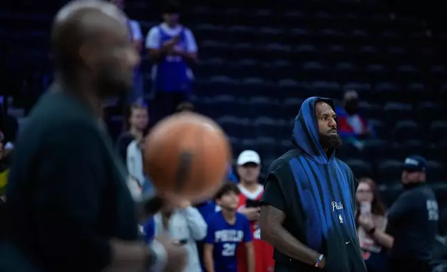 Philadelphia 76ers' LeBron James watches warm-ups before a preseason NBA basketball game against the Boston Celtics Friday, Oct. 16, 2026, in Philadelphia. (AP Photo/Matt Slocum)