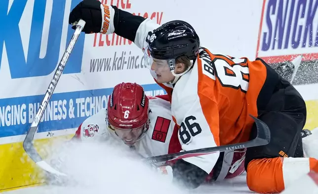 Philadelphia Flyers' Denver Barkey (86) and Carolina Hurricanes' Mike Reilly (6) collide during the second period of an NHL hockey game Sunday, Oct. 11, 2026, in Philadelphia. (AP Photo/Matt Slocum)
